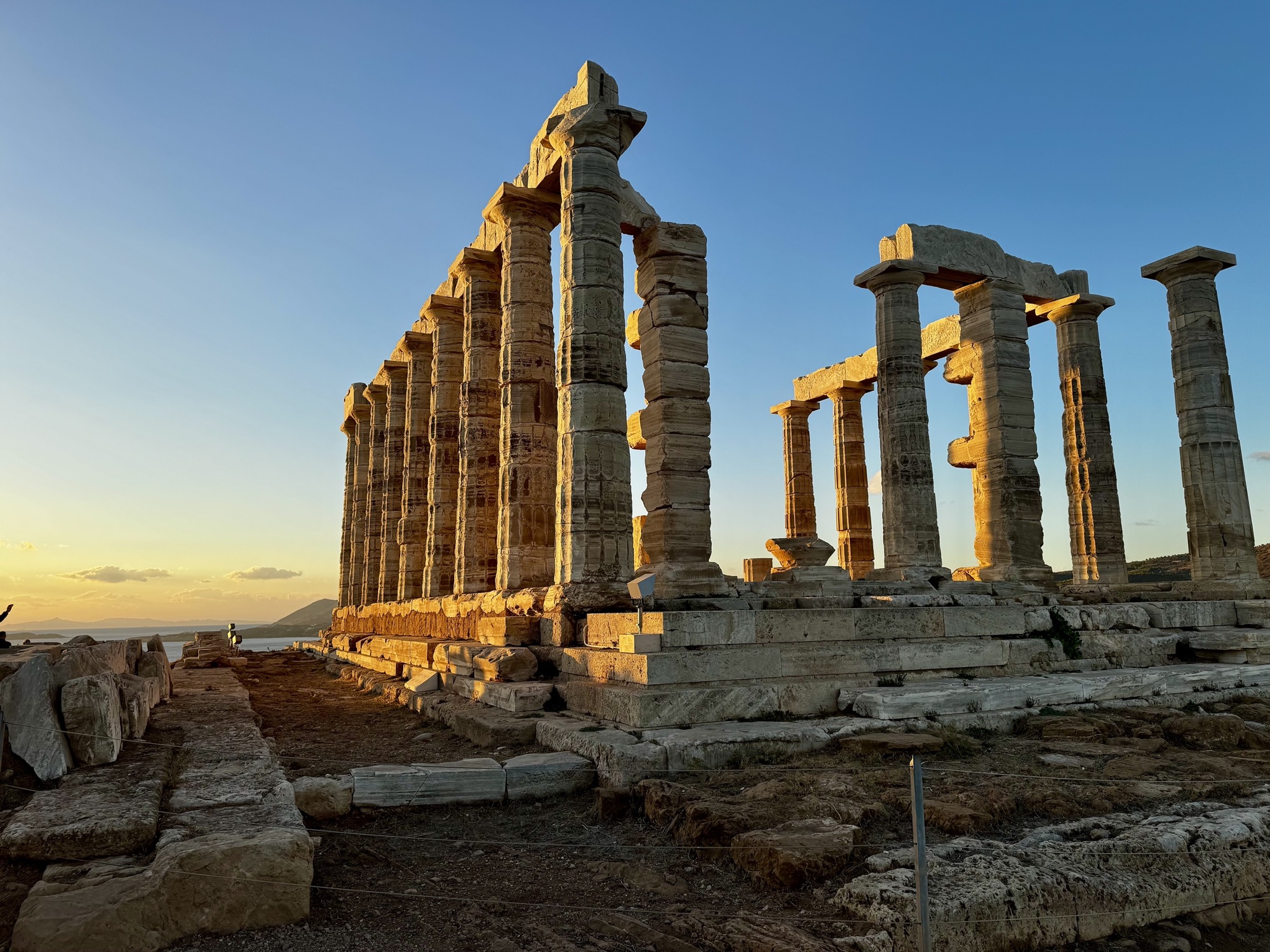 The Temple of Poseidon at Sounion, lit orange at sunset